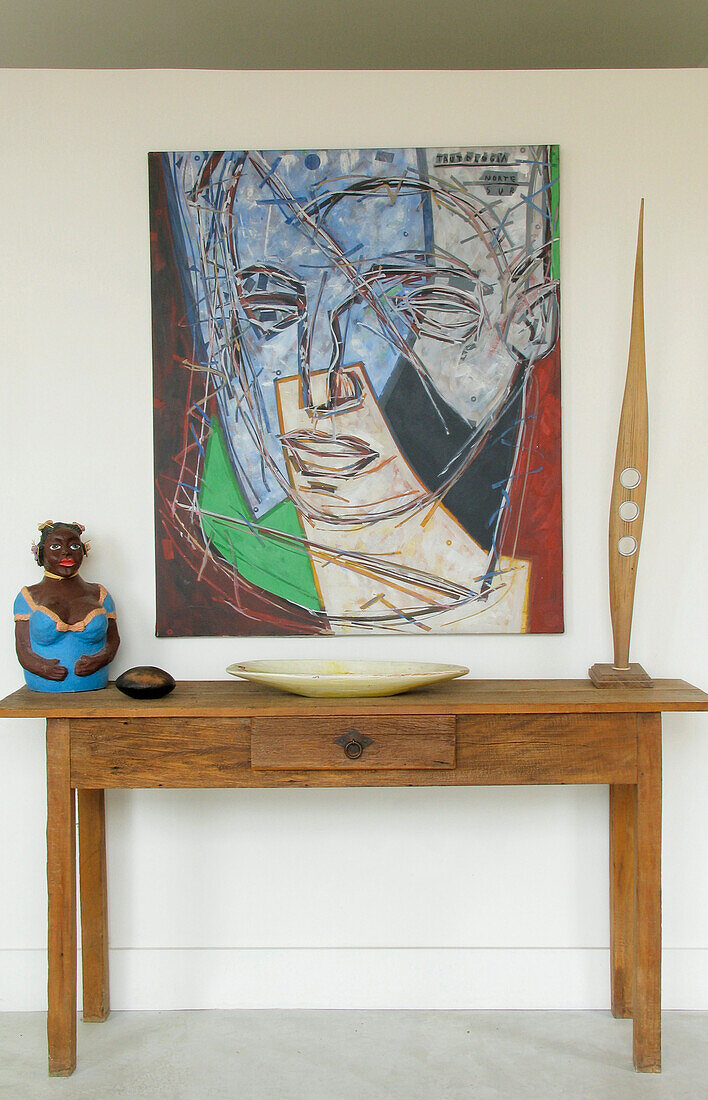 Sculptural ornaments and modern art in hallway with wooden table