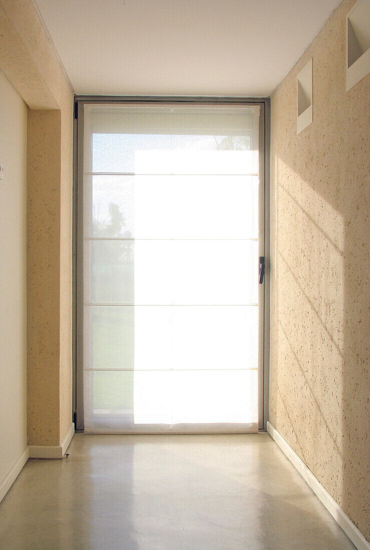 Circulation corridor with steel framework and gauze Roman blind