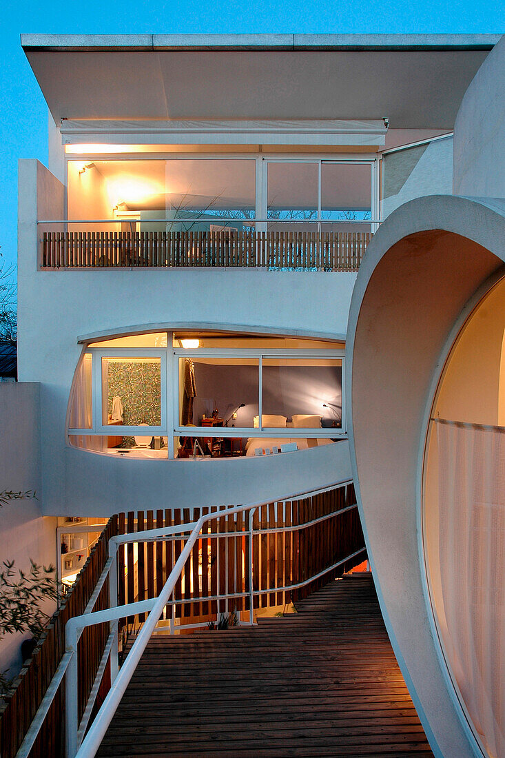 Modern facade stucco finished with white aluminium and windows in varying shapes