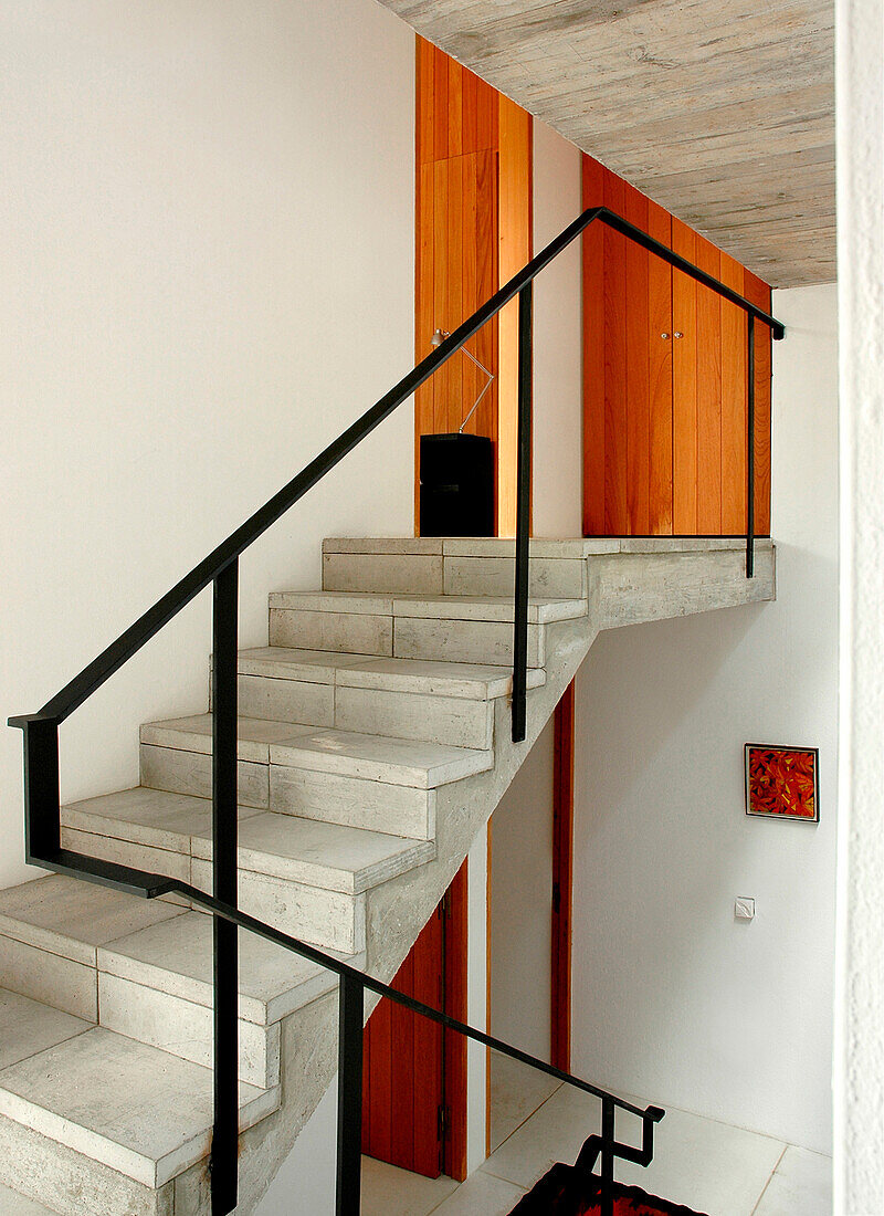 The open staircase from the ground floor to the bedrooms are built of small concrete squares with a steel handrail