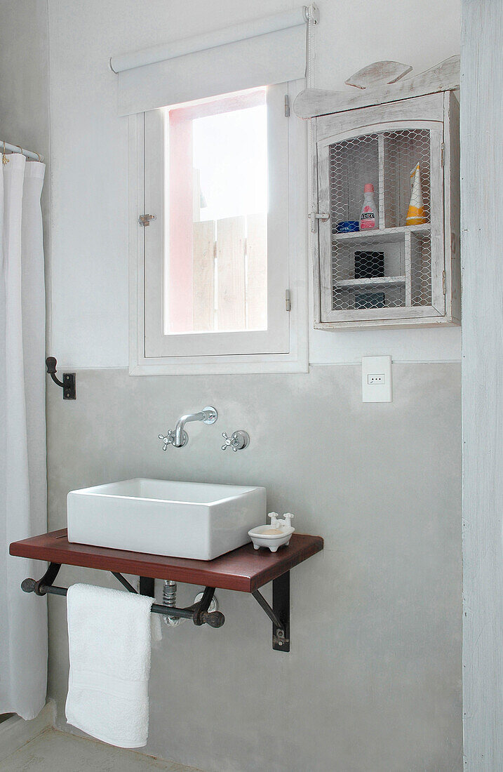 Wandmontierter Waschtisch und Schrank am Badezimmerfenster