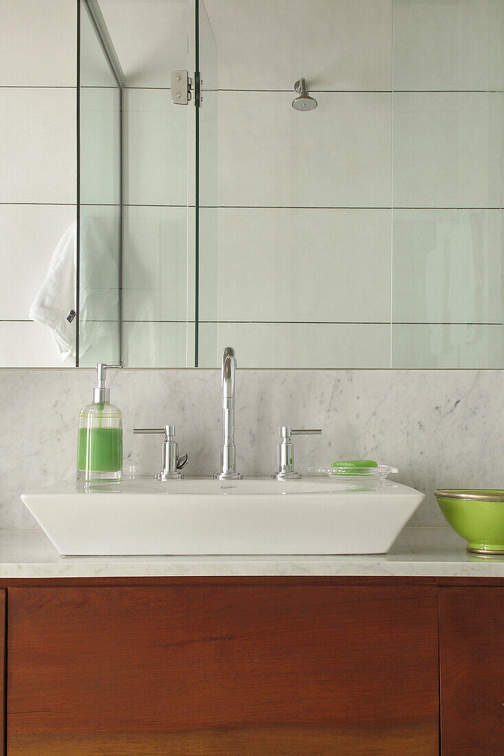 Wash basin on counter below mirror