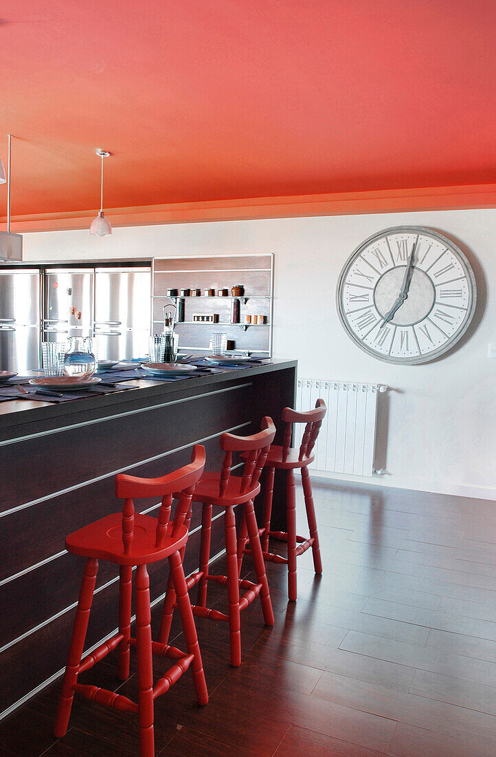 Küche mit roter Decke und übergroßer Uhr