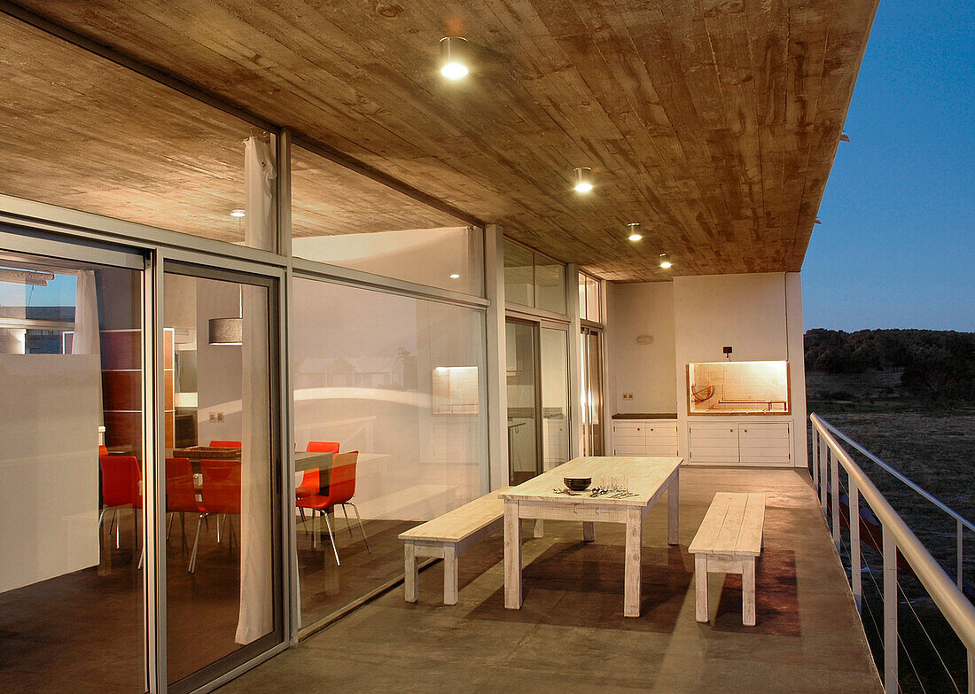 External kitchen and dining area on balcony with smoothed concrete floor