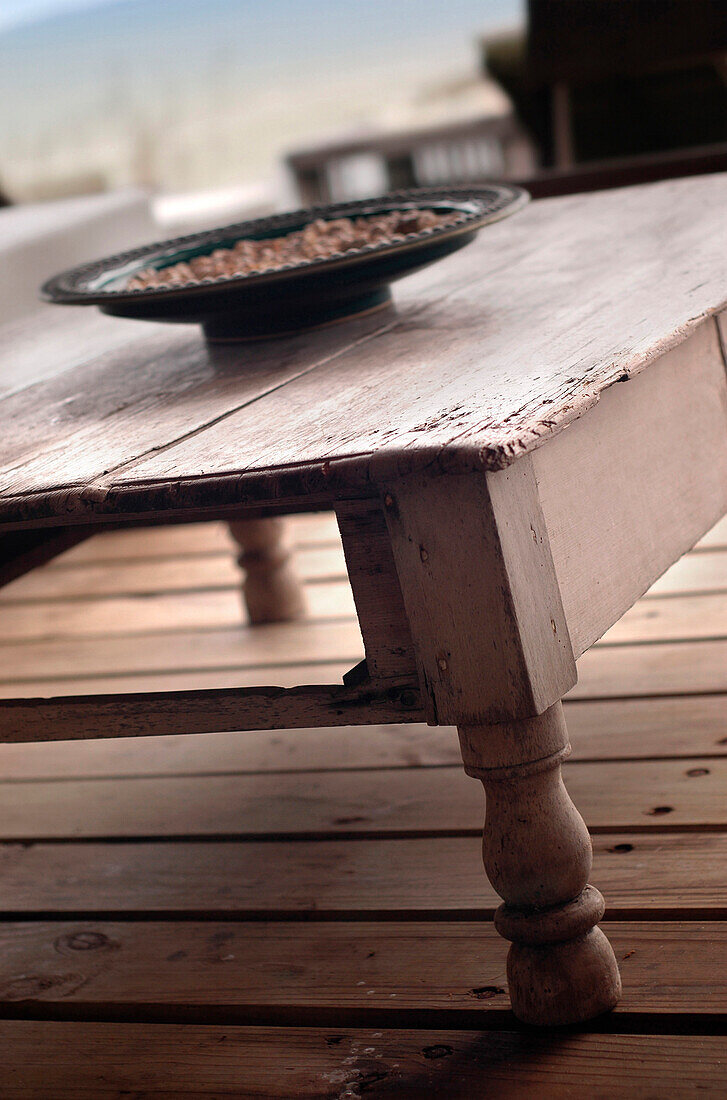 Seashells in bowl on weathered wooden table