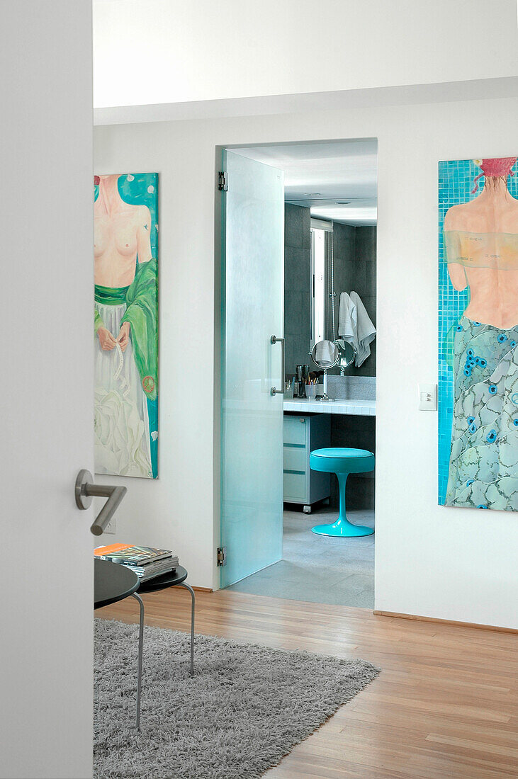 Blick aus dem Schlafzimmer mit modernem Kunstwerk durch die Tür zum eigenen Bad