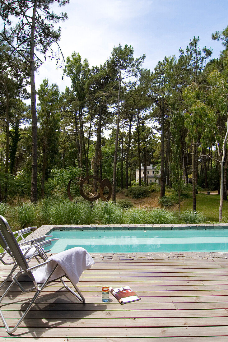 Folding chairs on decked terrace in woodland