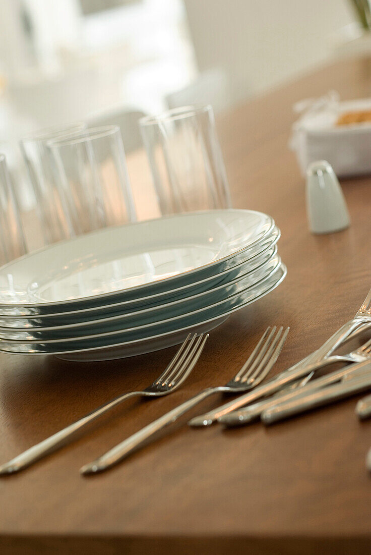 Plates and cutlery on wooden dining tabletop