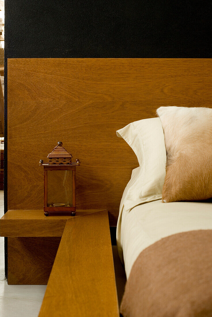 Lantern on shelf and wooden headboard