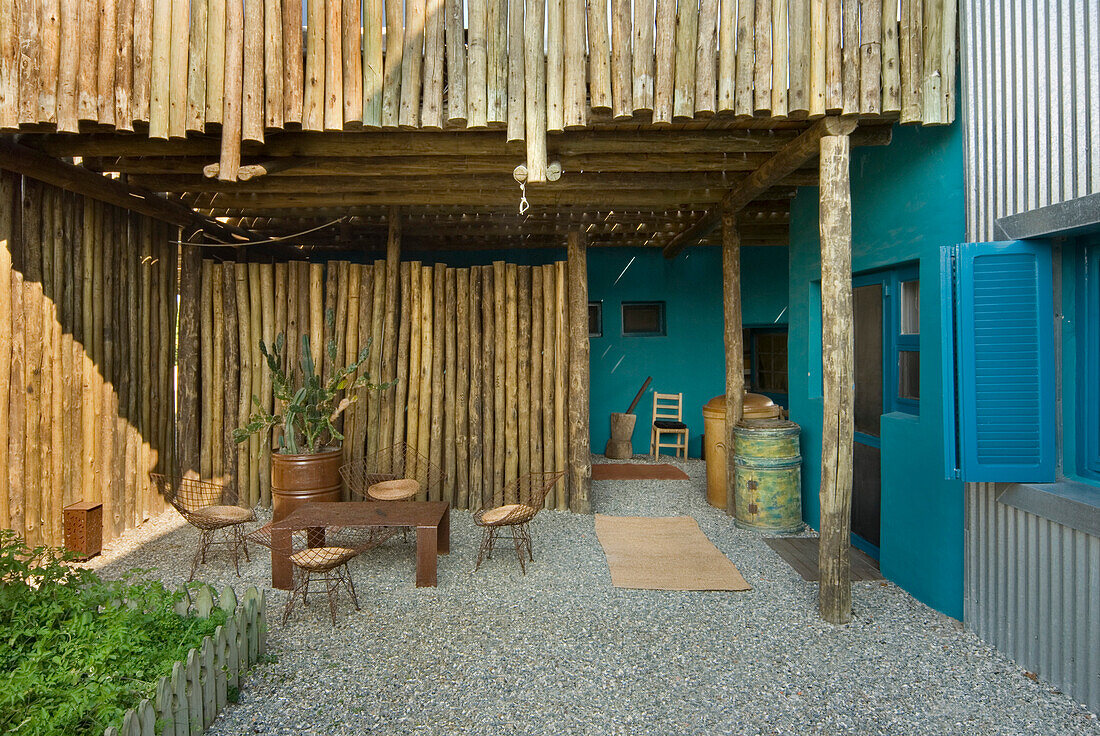 Rusty furniture in gravelled courtyard with herb garden