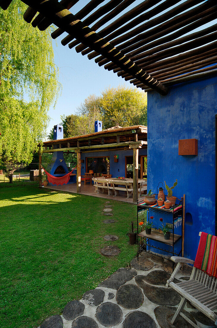 Private Veranda mit Holzdach und Blick auf den Garten mit Hängematte auf der hinteren Veranda