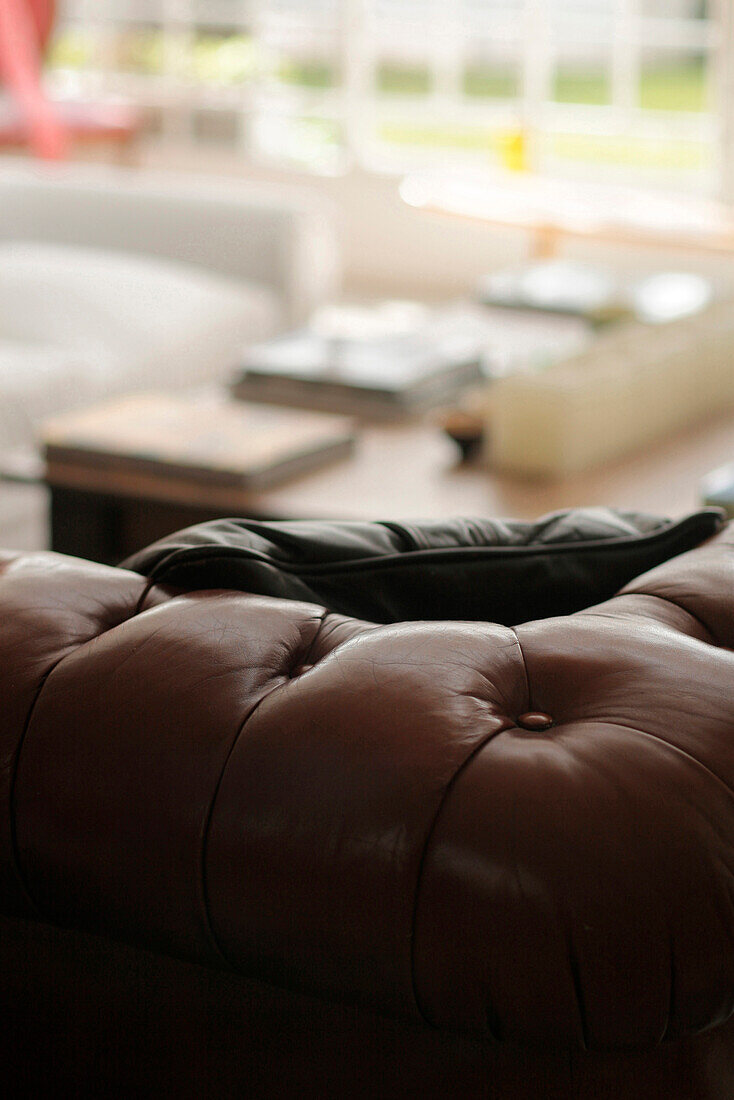 Leather cushion on brown Chesterfield sofa