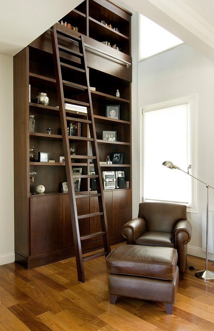 Rolling ladder against high bookshelves in living room, Pillar, Buenos Aires, Argentina