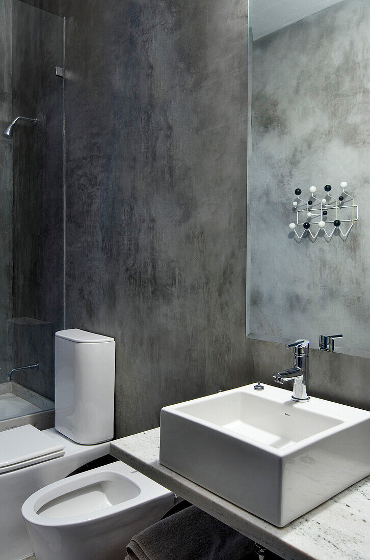 Wash basin and shower cubicle in concrete bathroom
