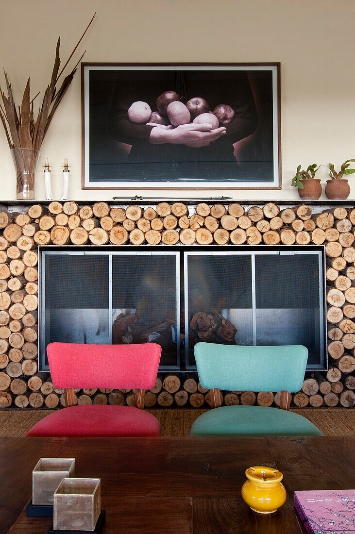 Uruguay, modern living room with fireplace and stacks of wood