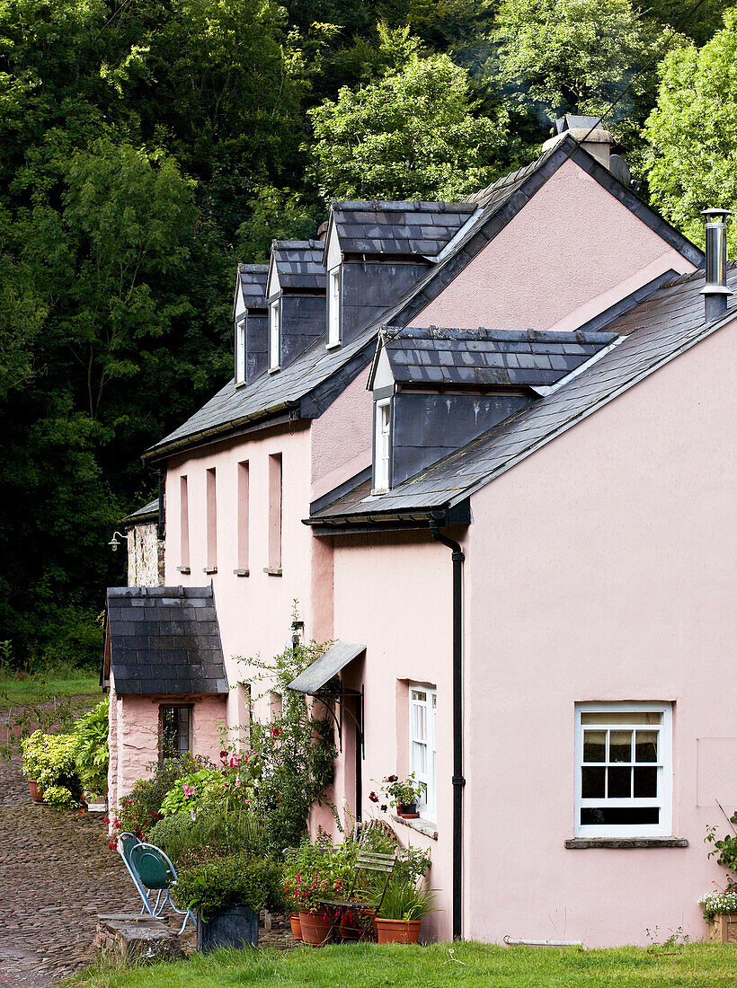 Pink country house with dormer windows and gravel approach