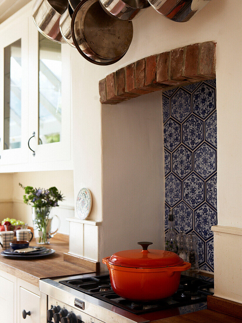 Casserole pan on gas hob with blue and white Moroccan tiling
