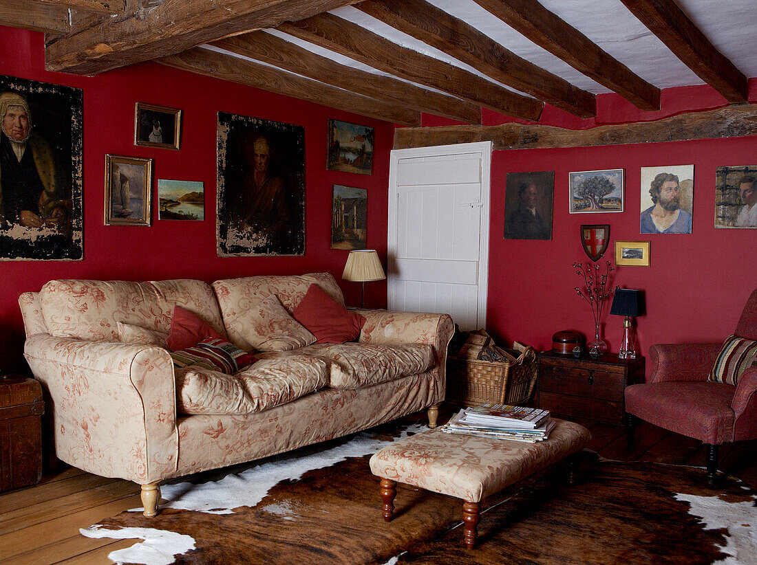 Beamed ceiling and dark red walls of 17th Century Oxfordshire living room