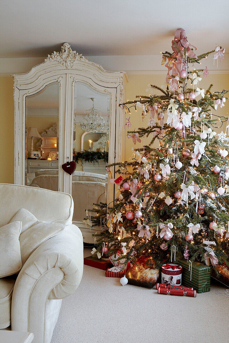 Wrapped presents under Christmas tree with pink decorations