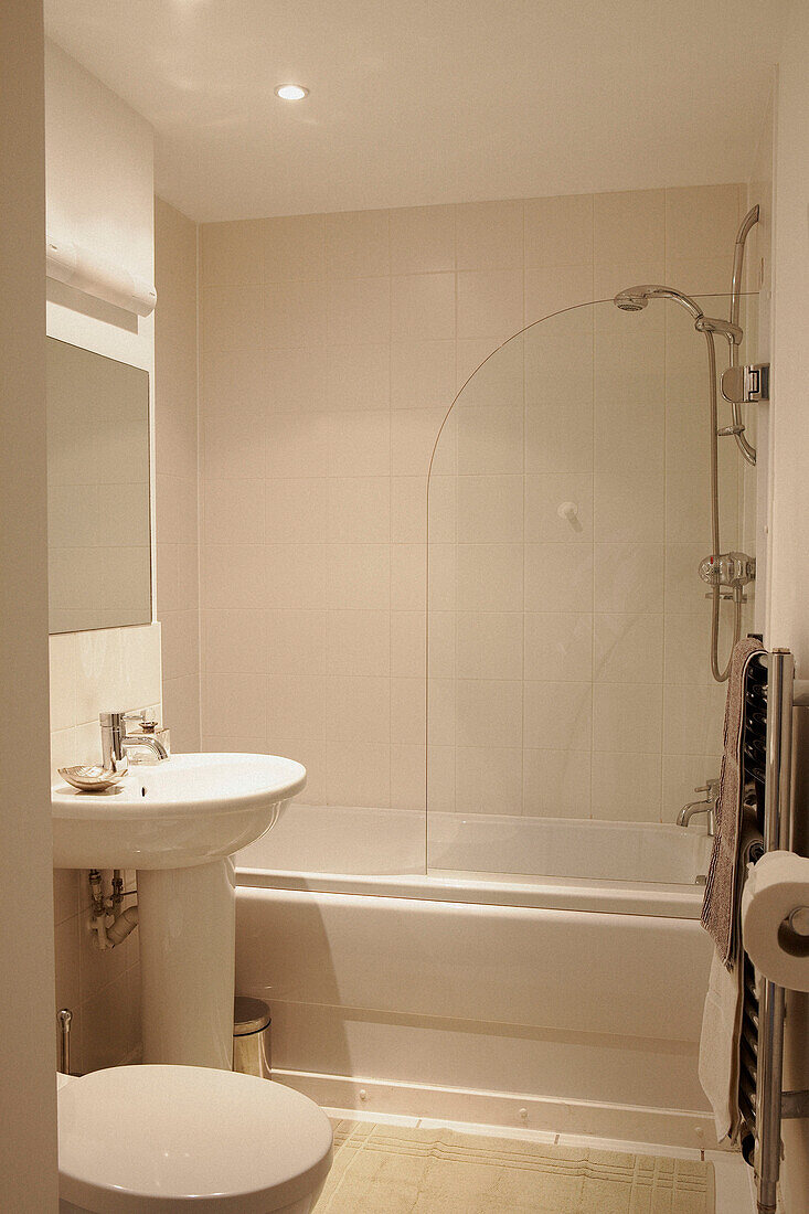 Weiß gefliestes Badezimmer und Duschabtrennung