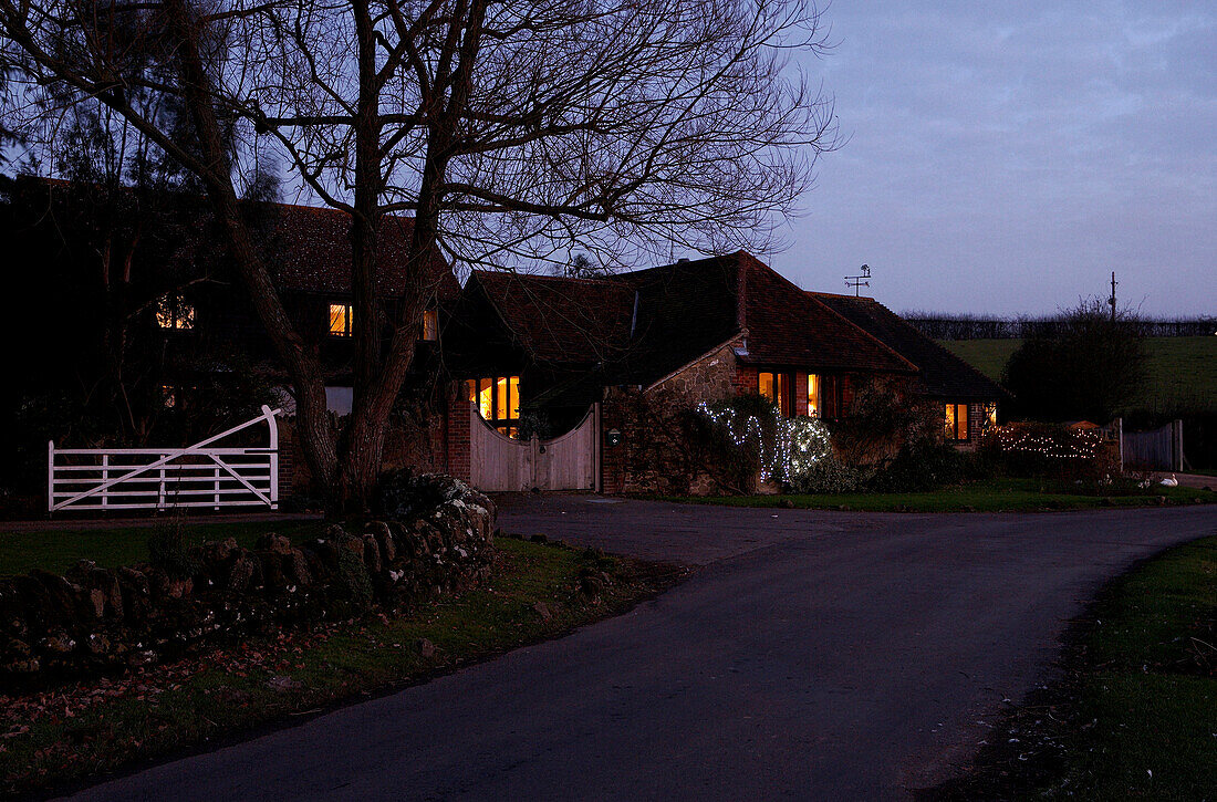 Beleuchtete Außenfassade eines Landhauses in der Abenddämmerung