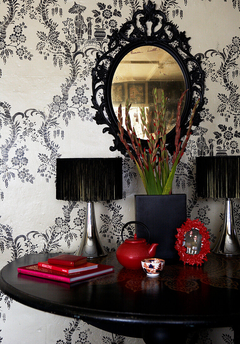 Ornate black mirror and fringed lamps on Georgian farmhouse kitchen table