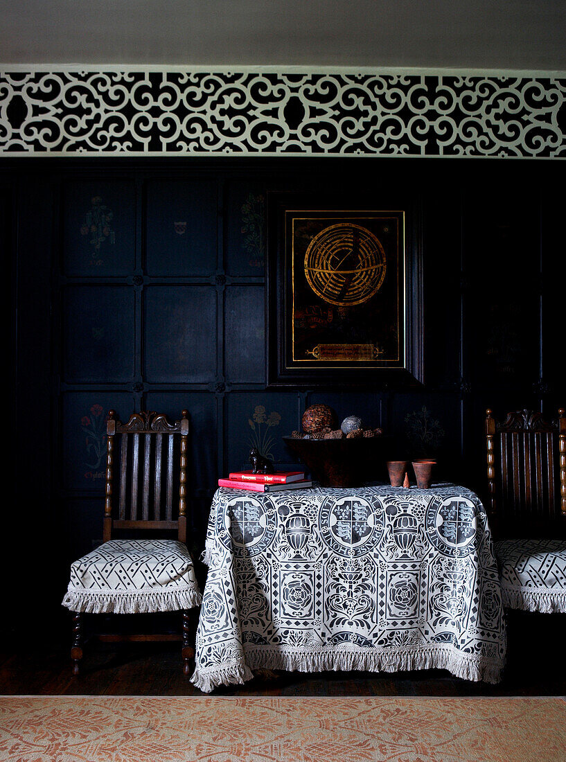 Black and white fabrics on side table and chairs in panelled Georgian farmhouse 