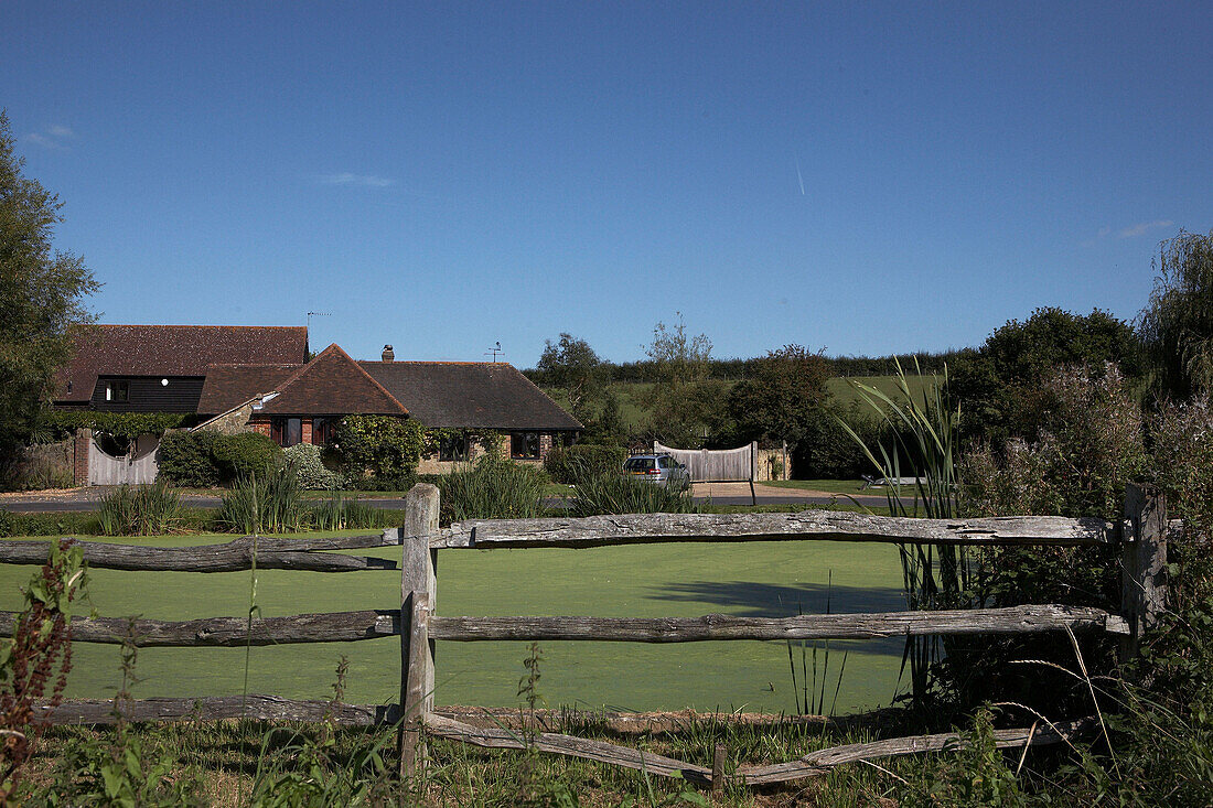 Fenced lake and tiled countryside house