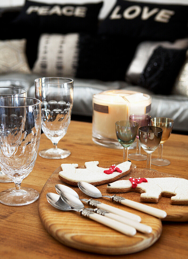 Mismatched glassware and Christmas biscuits on wooden tabletop