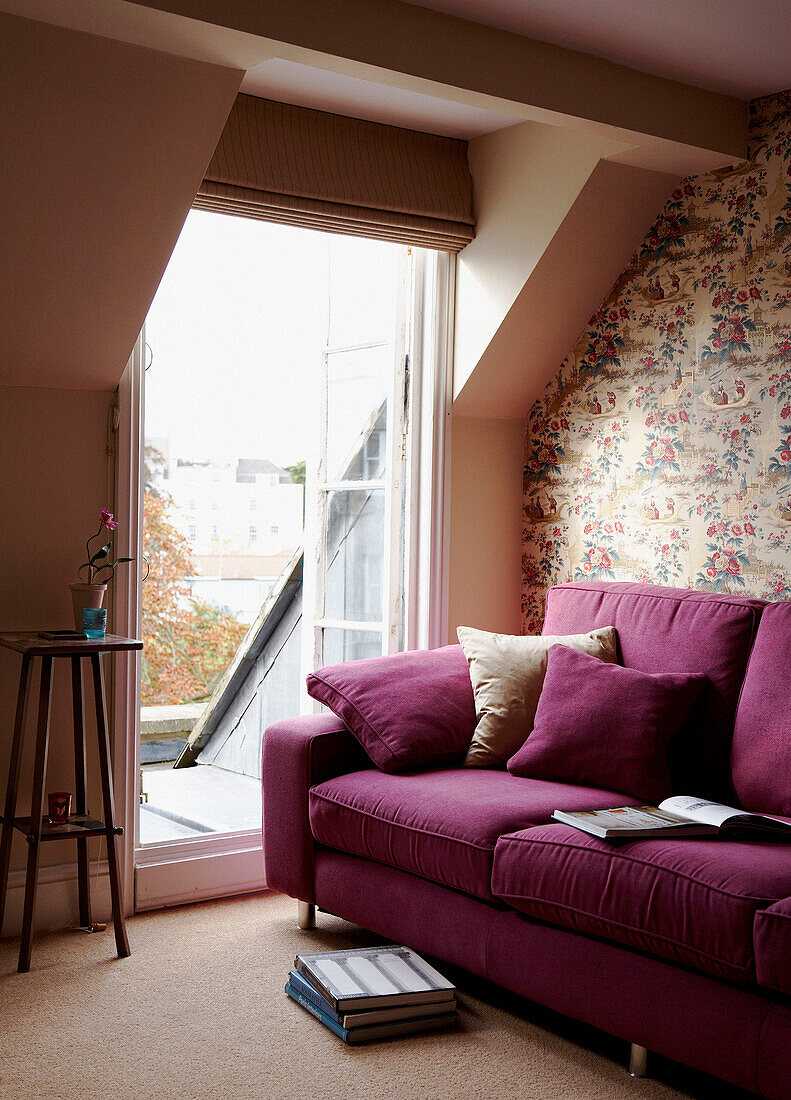 Fuchsie-Sofa im Wohnzimmer mit offenen Türen zur Dachterrasse in einem georgianischen Stadthaus