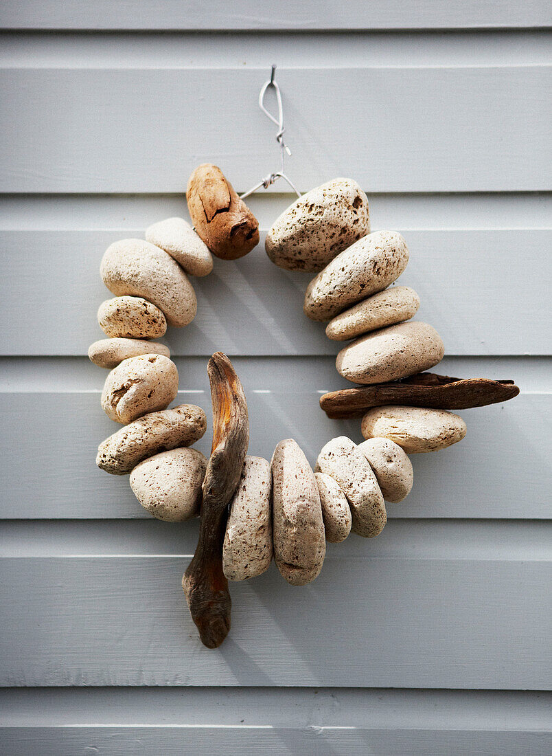 Natürliche Felsen und Treibholzornamente auf getäfelter Hausfassade Wairarapa Nordinsel Neuseeland