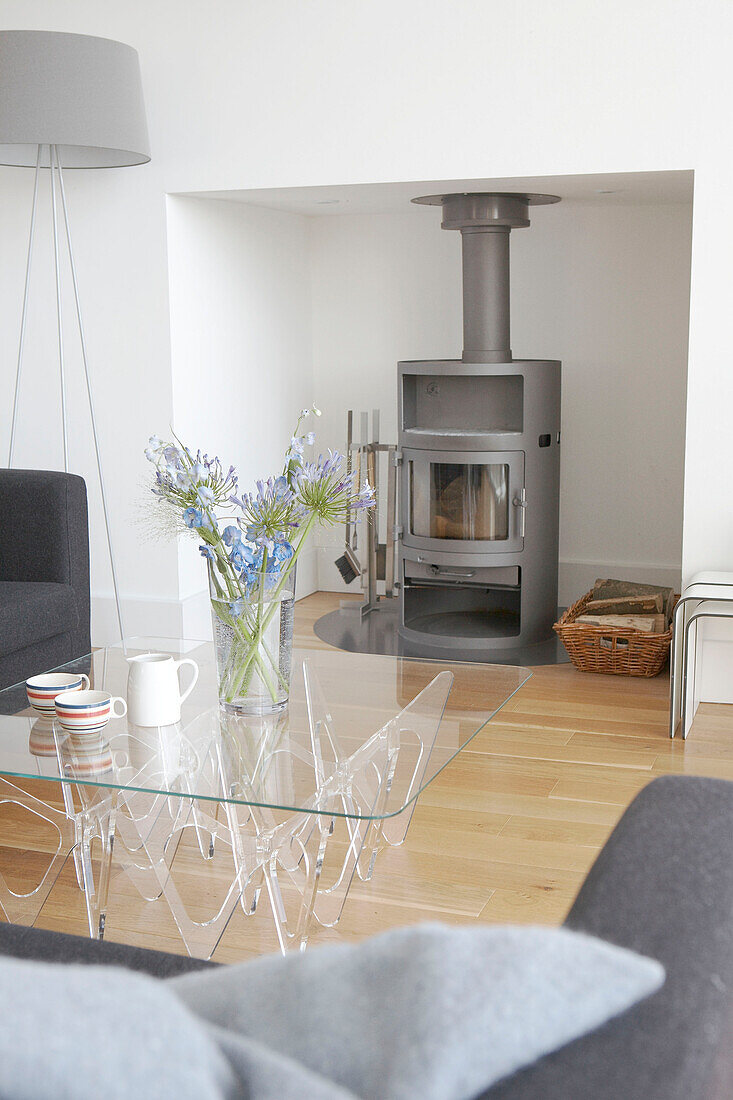 Holzofen und Couchtisch mit Glasplatte in einem nachhaltigen Wohnhaus in Gloucestershire