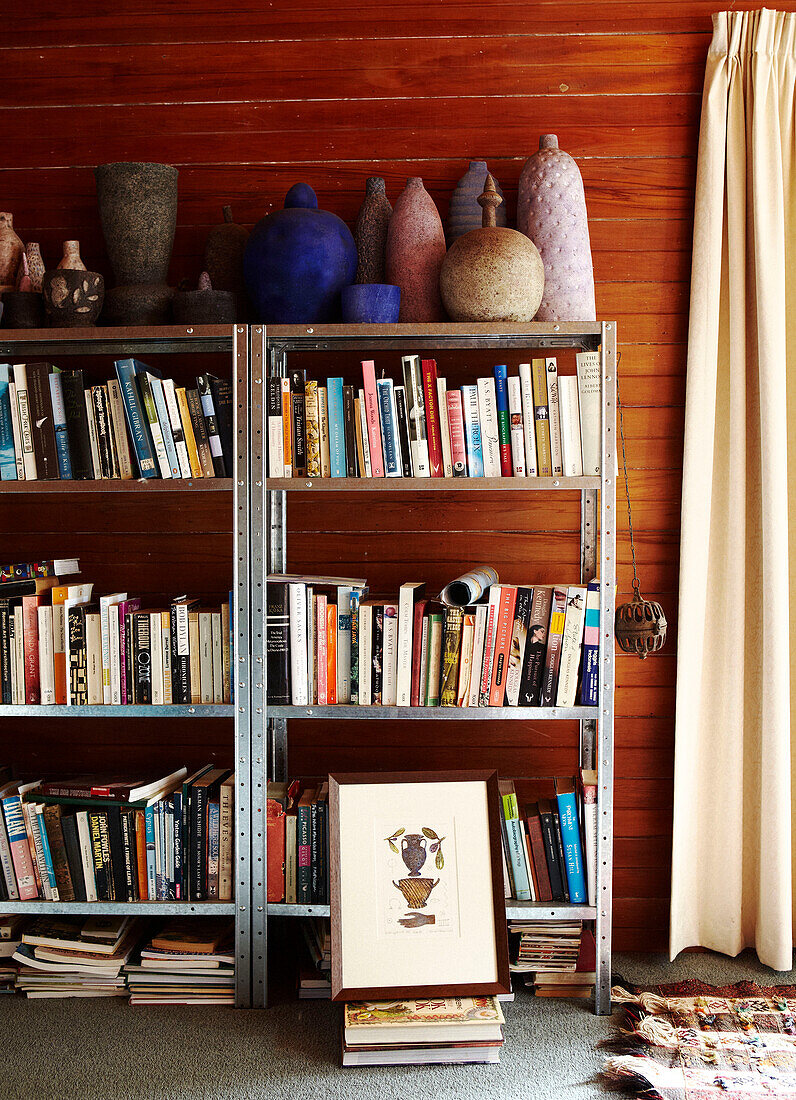 Metal framed bookcase with pottery ornaments in panelled room Masterton New Zealand