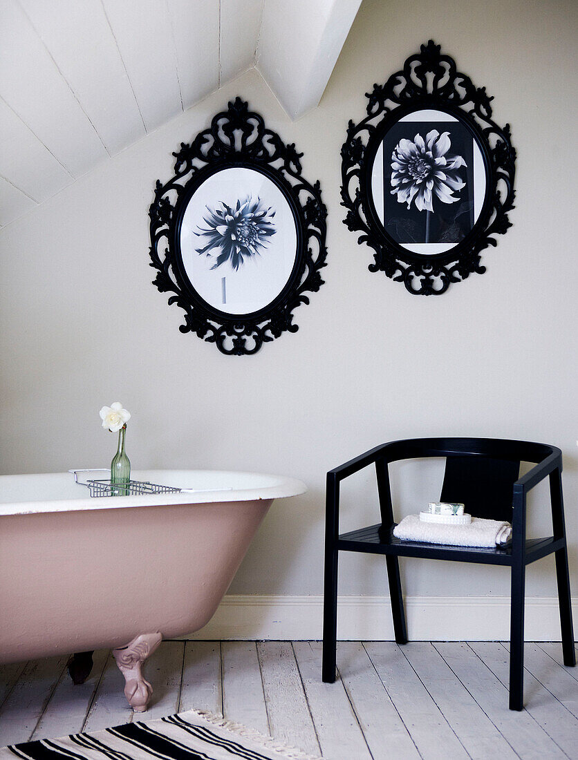 Attic bathroom with metal picture frames and pink freestanding bath