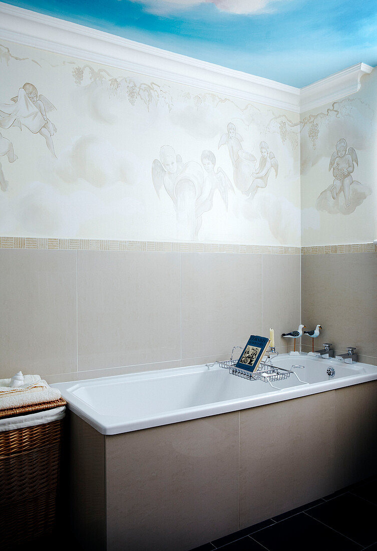 Cherub wallpaper and fresco of sky above bath with wire rack