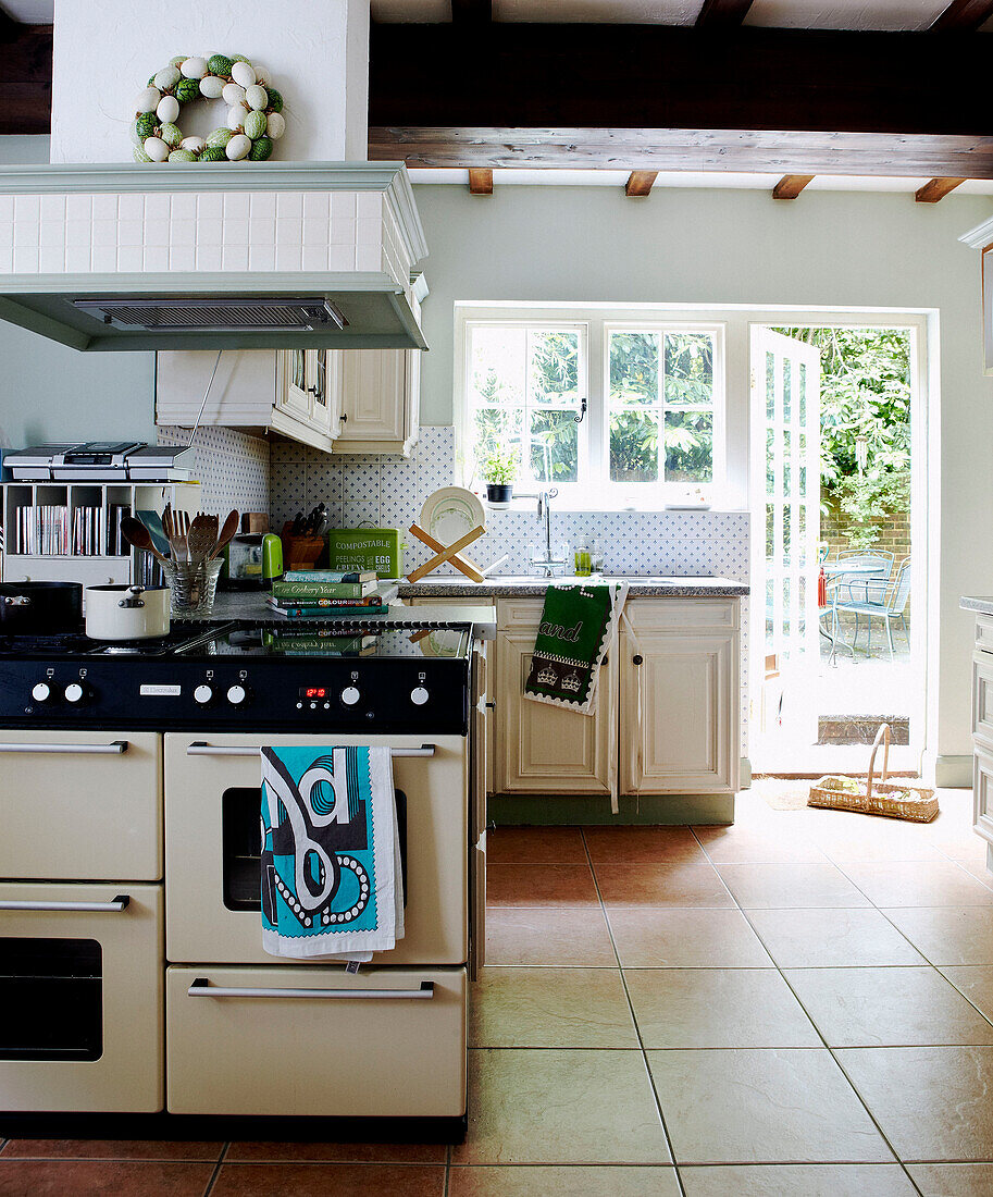 Range oven with extractor in tiled kitchen with sunlit back door