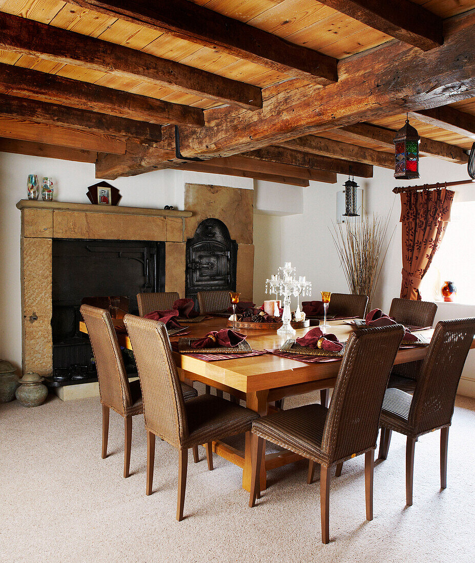 Holzbalkendecke in einem Esszimmer im Landhausstil mit Tisch und Stühlen