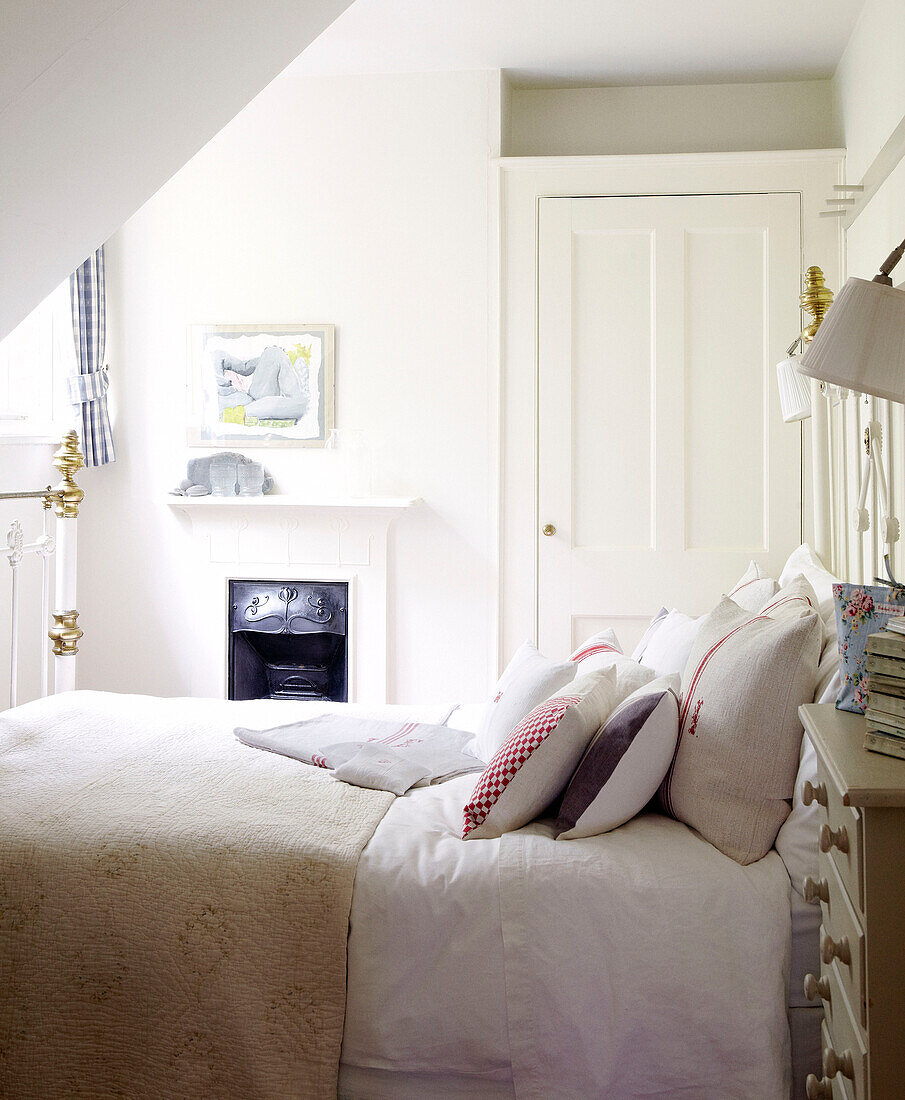 Fabric cushions on bed in room with original fireplace