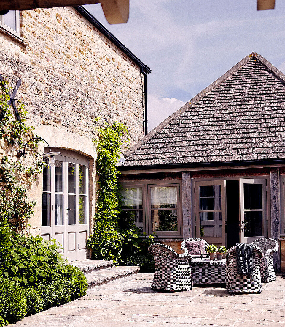 Wicker table and chairs in farmhouse courtyard exterior