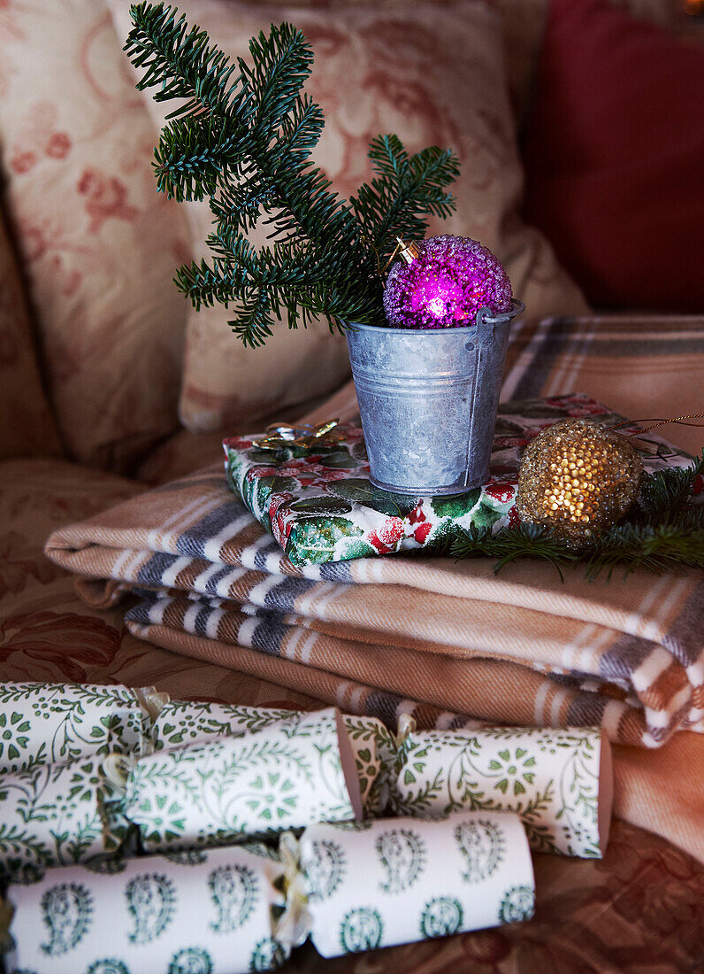 Tannenzweig und Weihnachtskugeln mit Crackern und gefaltetem Tischtuch