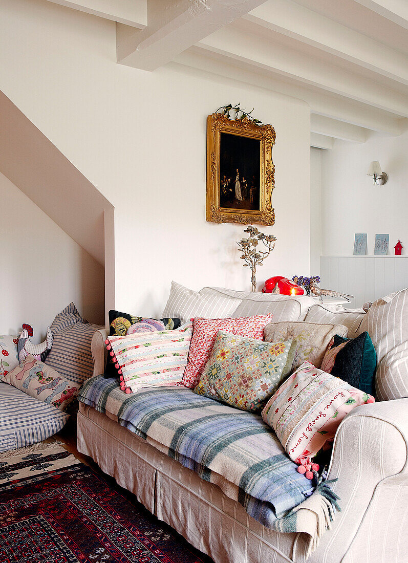 Woolen blanket and cushions with historic gilt framed artwork