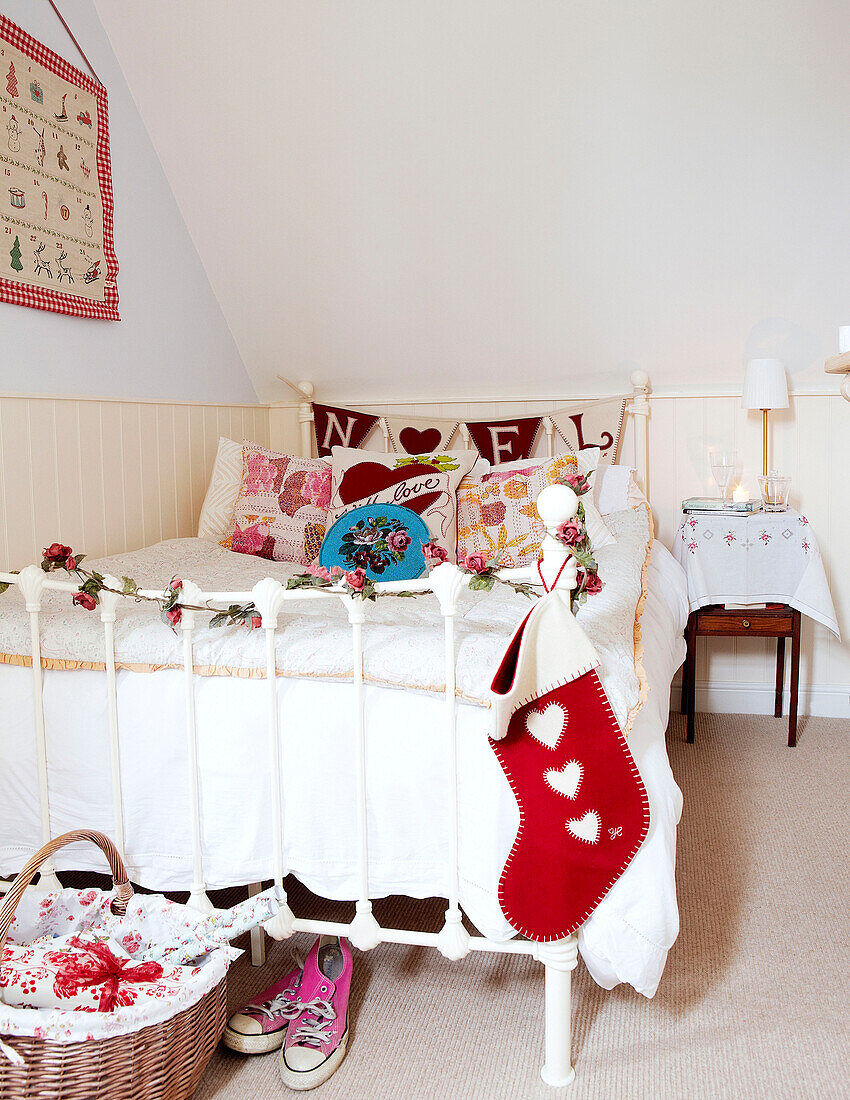 Christmas stocking hangs on metal footboard of bed