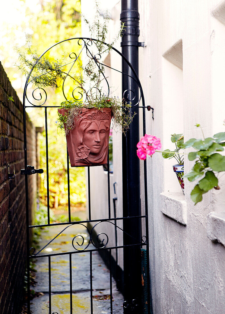 Metal side gate with flower planter and drainpipe