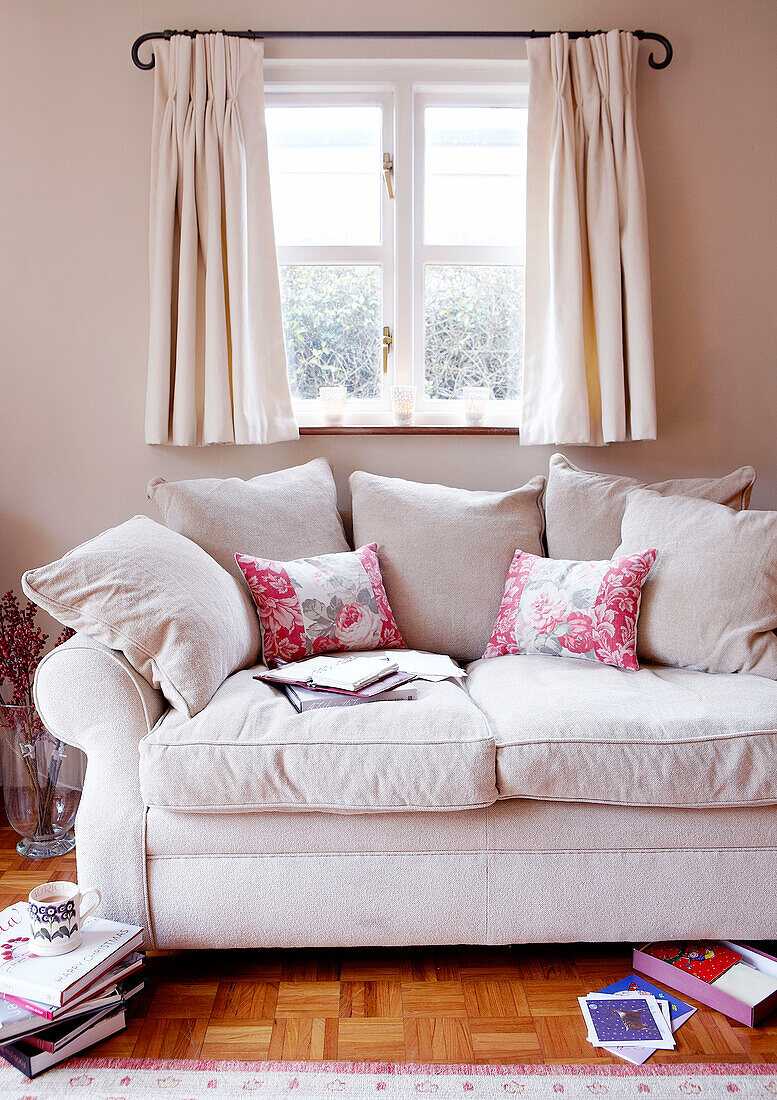 Cream sofa below window with books