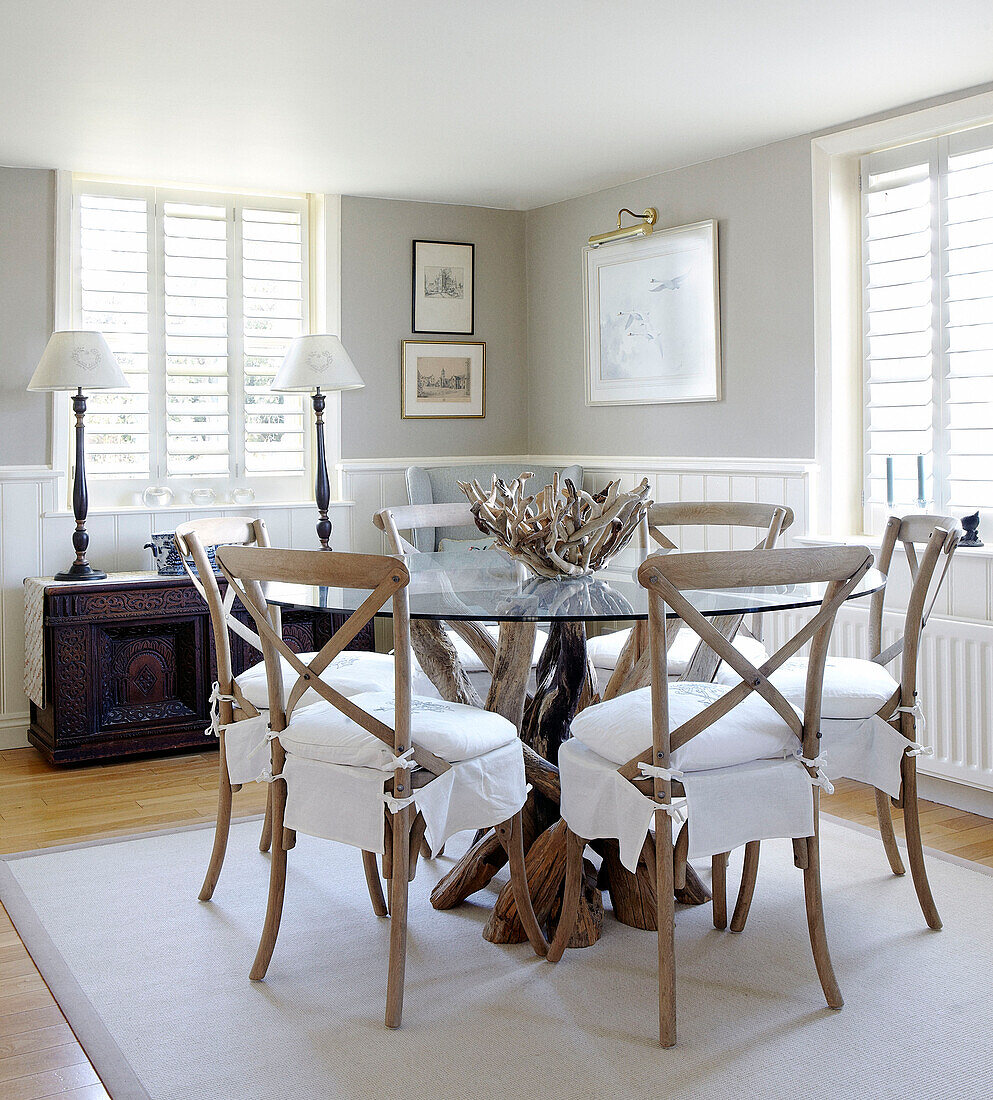 Glass topped dining table made from driftwood in dining room of Hampshire home England UK