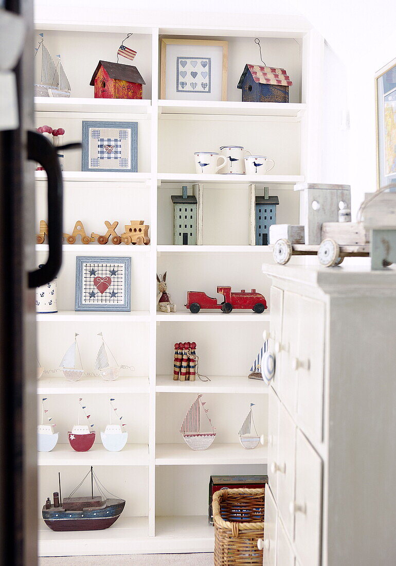 View through doorway to shelf storage in child's room in Forest Row farmhouse Surry England UK