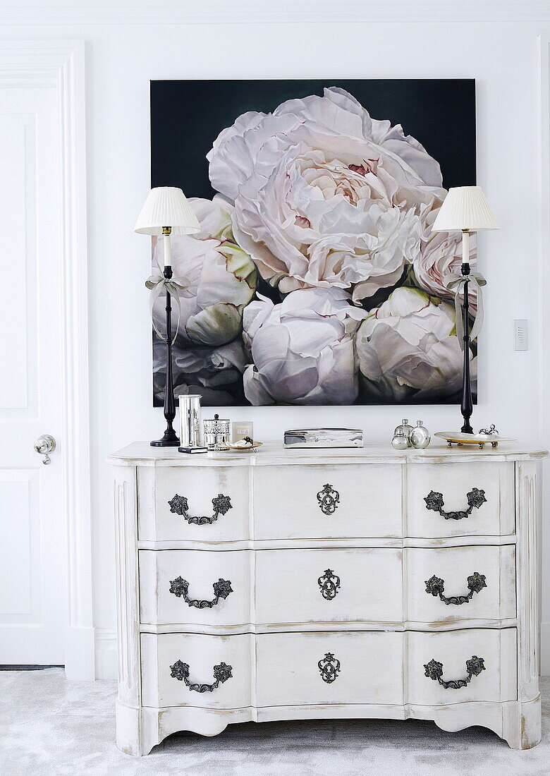 Großer Blumendruck und Silberbesteck mit weißer antiker Kommode in einem Londoner Haus UK