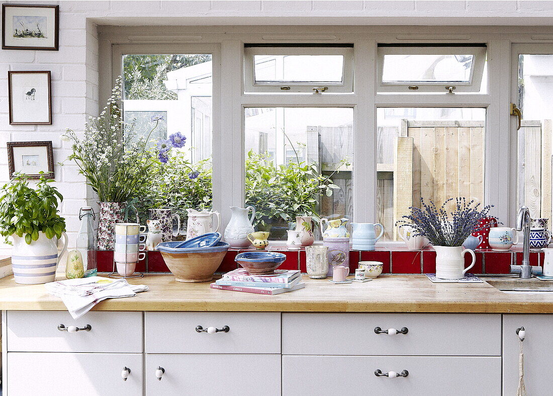 Cut flowers and crockery on windowsill of London home UK