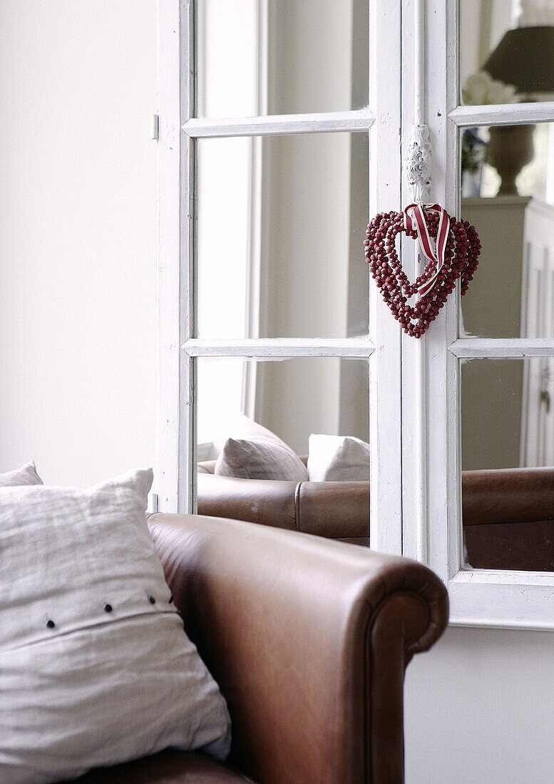 Heart shaped ornament hanging on salvaged window mirror in country house Tunbridge Wells Kent England UK