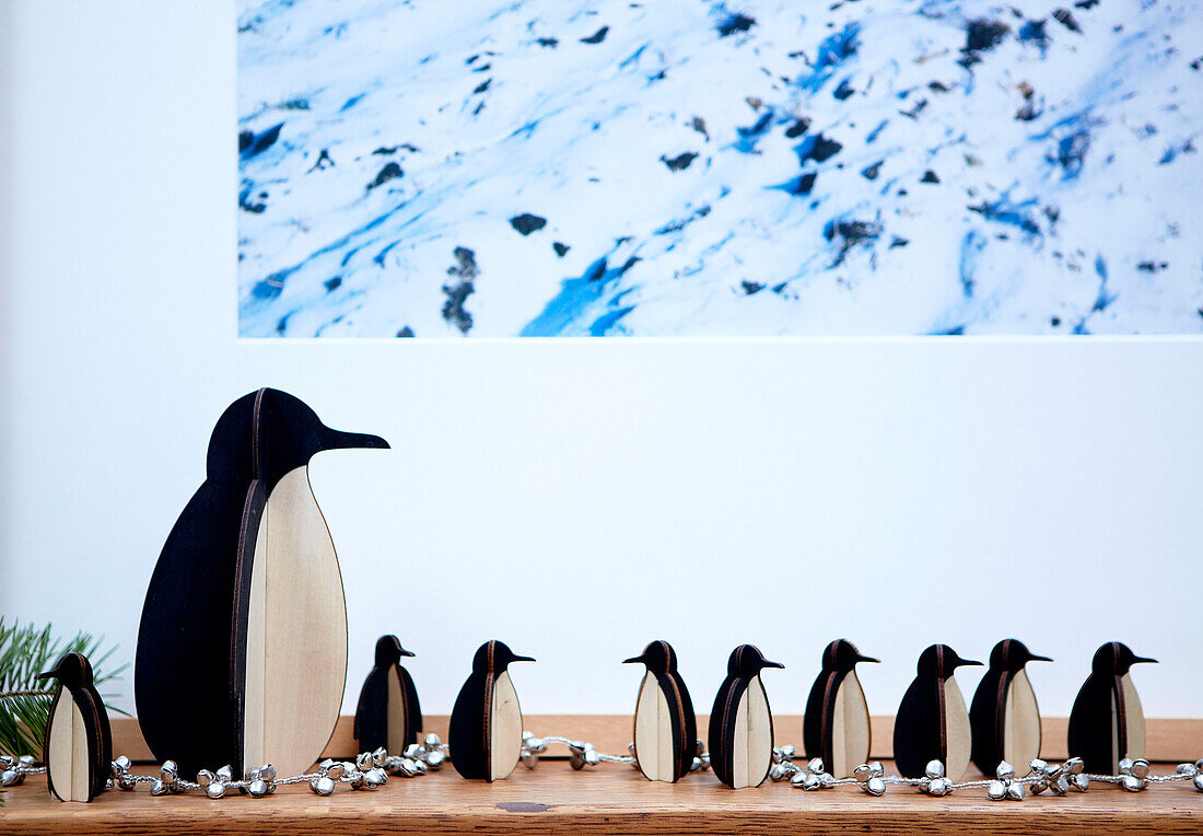 Penguin family on wooden shelf in London home England UK